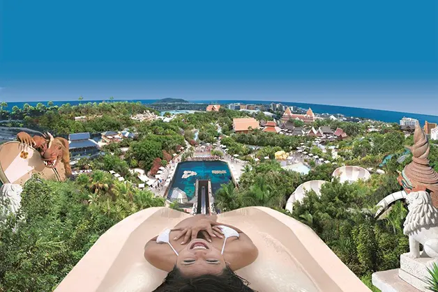 Woman relaxing on a water slide overlooking Siam Park in Tenerife.